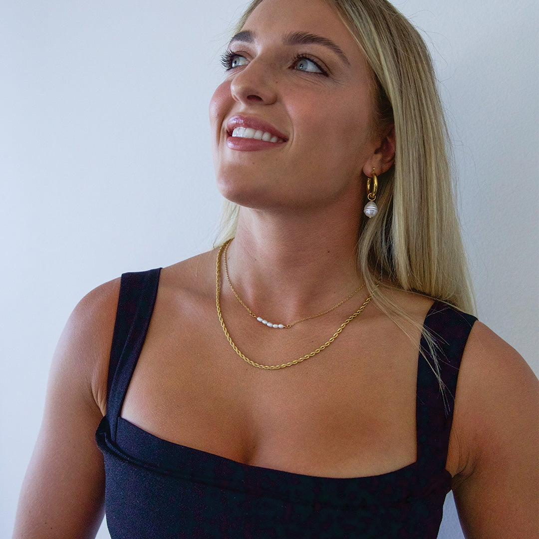 Blonde model wearing gold plated necklace with pearls smiling Australia