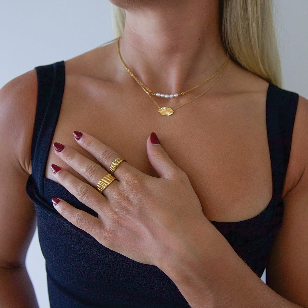 Blonde model wearing chunky ribbed gold plated ring