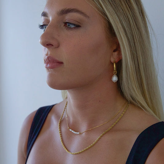 Model wearing gold plated  necklace with pearls