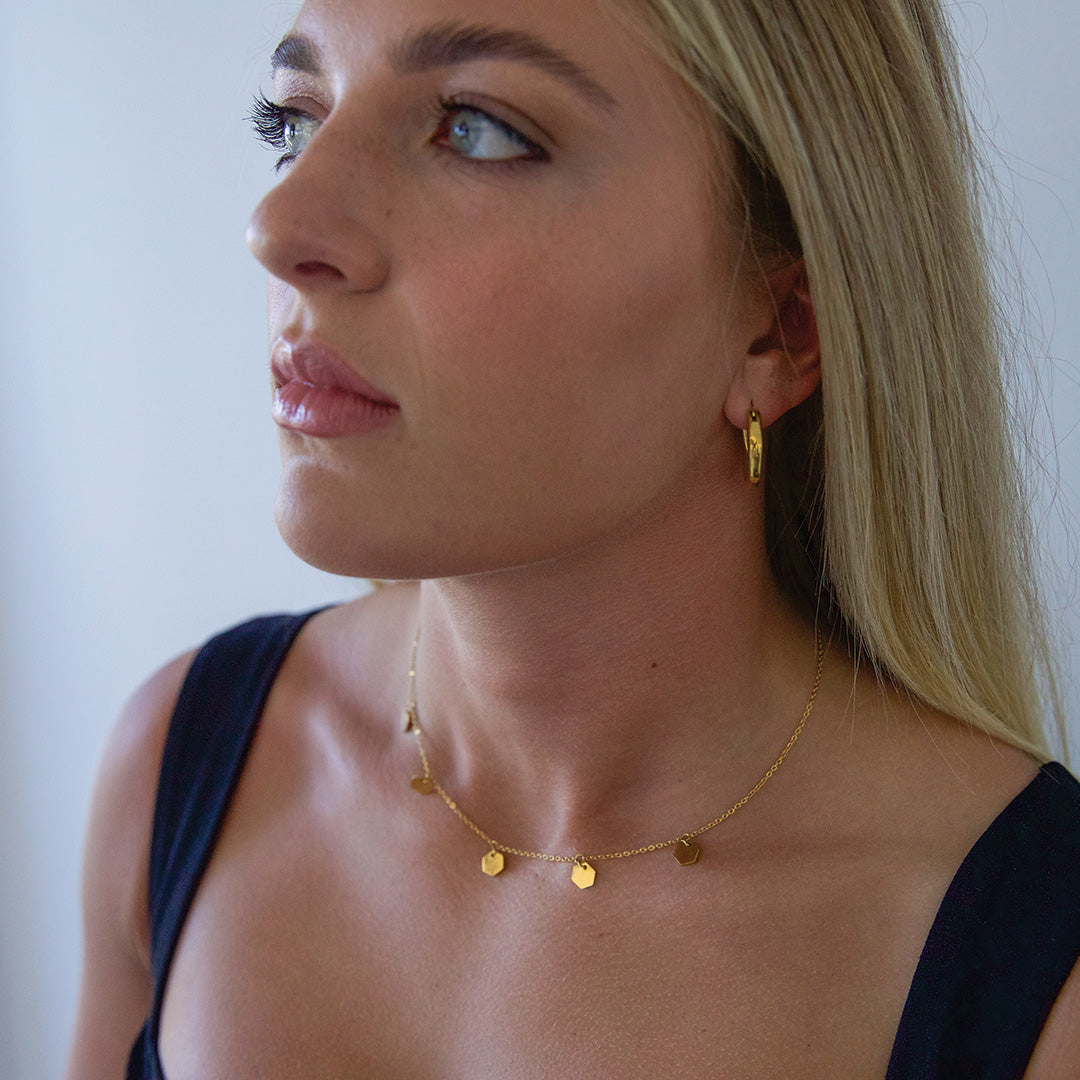 Blonde model wearing hexagon hanging gold plated necklace